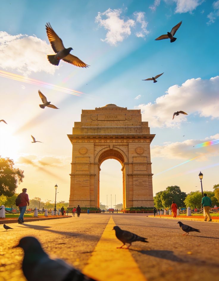 India Gate war memorial in New Delhi India at sunset with pigeons flying and tourists walking, famous Delhi sightseeing landmark and popular India tourism destination