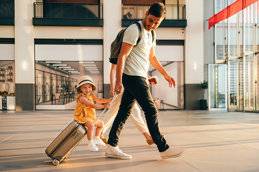 International family tour packages from India, happy father and child traveling at airport with suitcase, best travel agency for family vacation booking and holiday trips